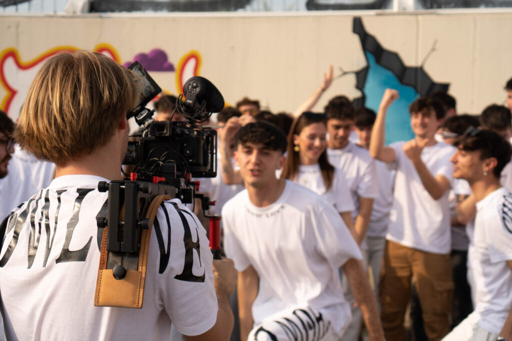 Un ragazzo della troupe riprende con la telecamera il gruppo che festeggia
